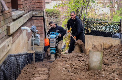 Aquatech Waterproofing worker operating equipment during trench excavation for foundation waterproofing