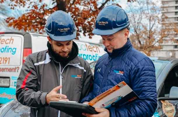 Basement waterproofing specialists working on a home project