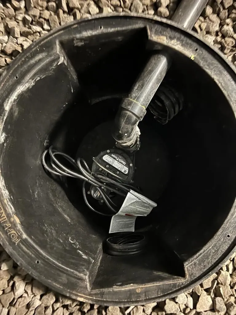 Aquatech Waterproofing secondary battery backup sump pump installed inside basement drainage pit