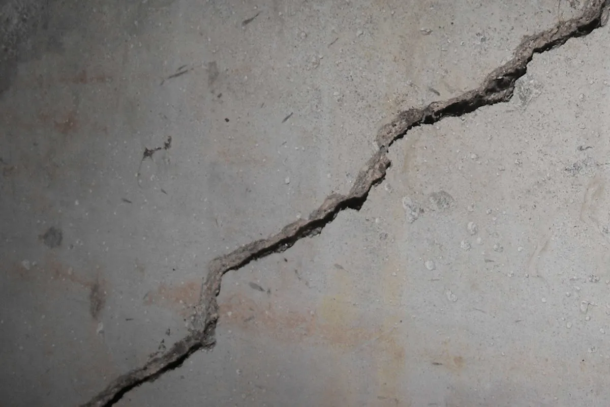 Diagonal structural stress crack running along a concrete basement foundation wall
