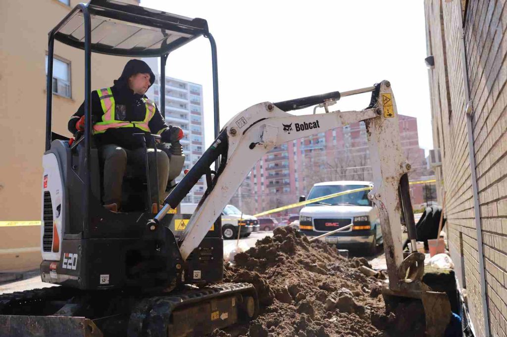 aquatech waterproofing worker bobcat excavator street 01
