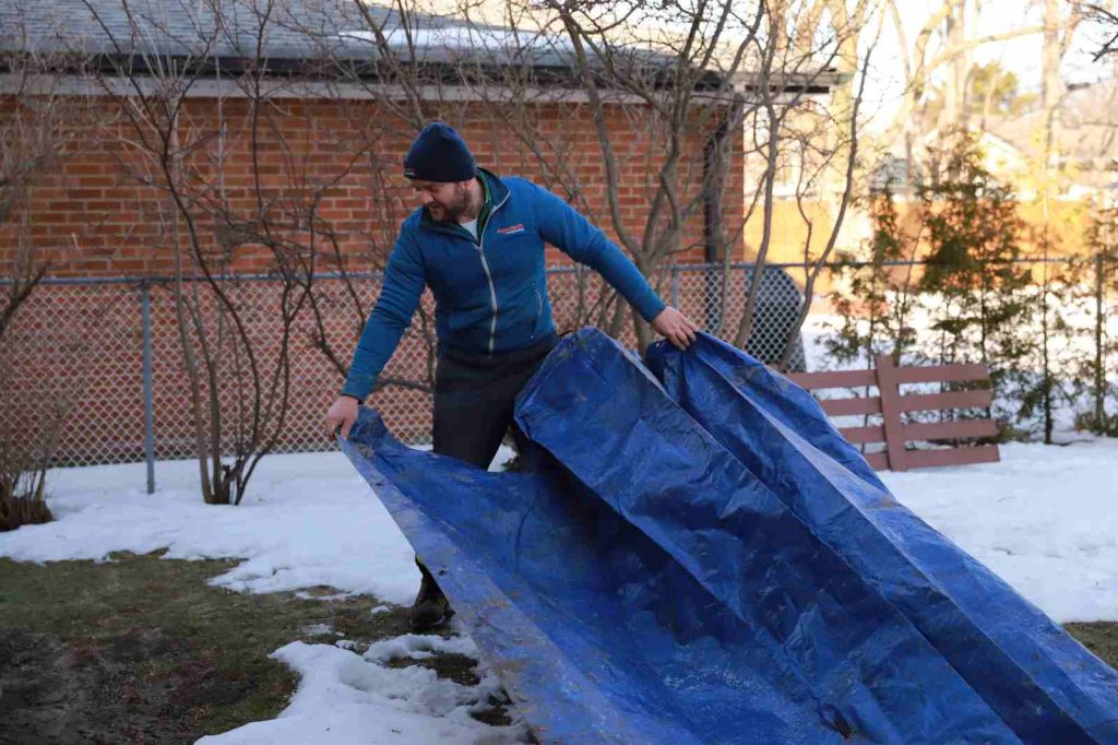 aquatech waterproofing worker tarp snowy yard 01